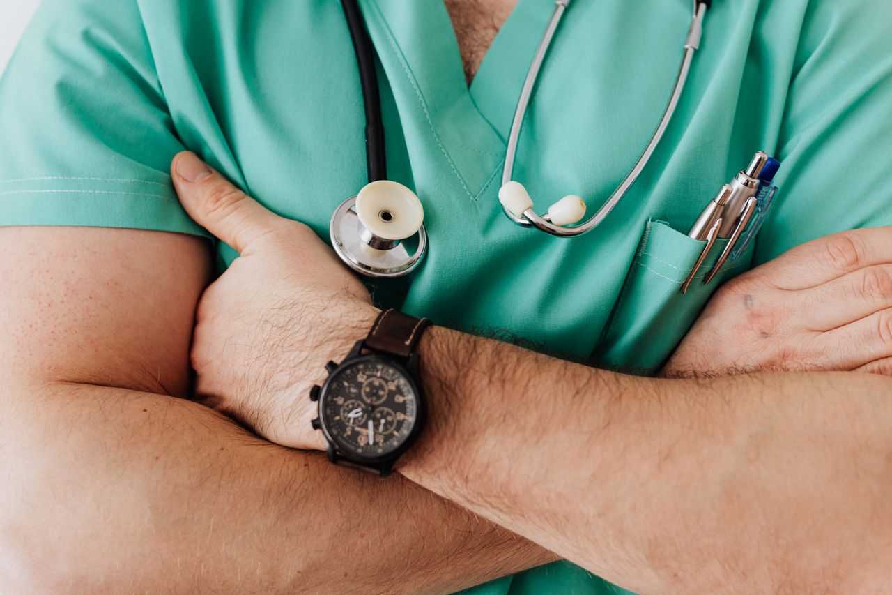 get-in-touch Unrecognizable female doctor in medical uniform with wristwatch on hand crossing arms on chest while standing with stethoscope on neck