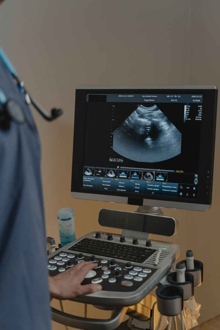 our-story A healthcare professional using an ultrasound machine in a clinical setting.