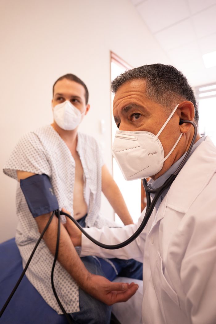 services-04 Healthcare professional measuring a patient's blood pressure during a clinical consultation.